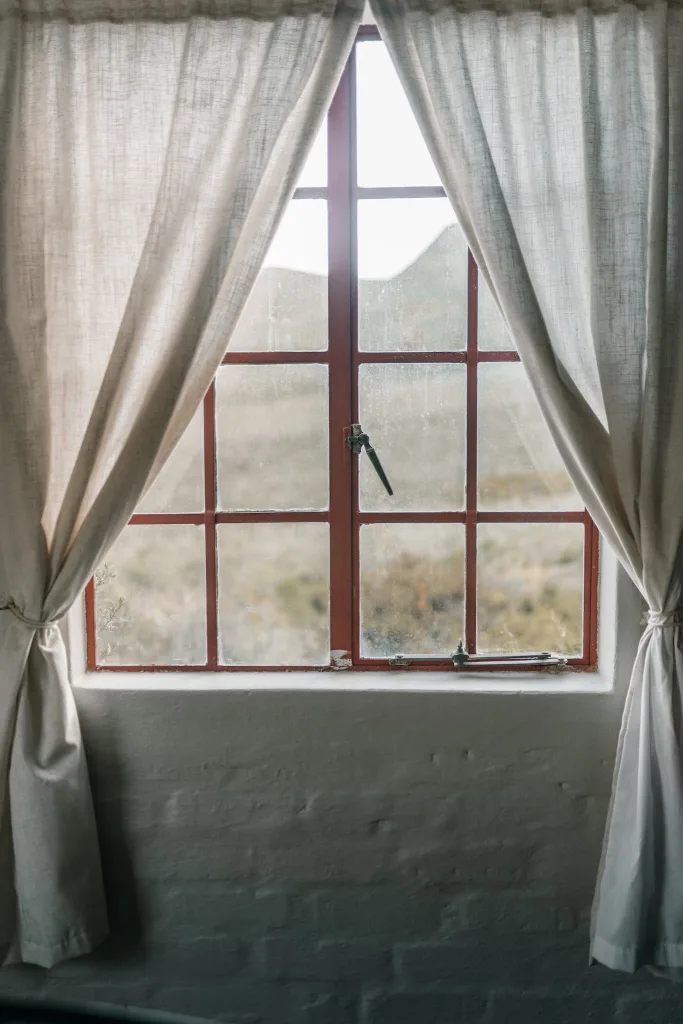 Red Framed Glass Window with White Curtains