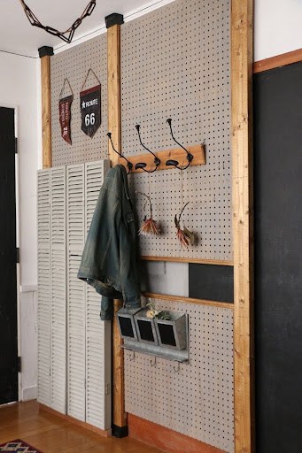 A rustic-inspired entryway nook with a pegboard organizer flanked by wooden accents.