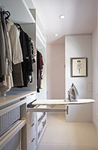 A minimalist walk-in closet with a built-in ironing board for a quick touch-up on clothes.
