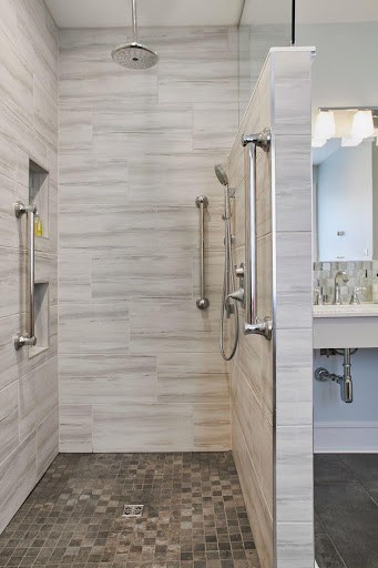 Modern tiny bathroom Open Shower with Half Wall with horizontal grey tile design, glass door, and wall-mounted shower fixtures.