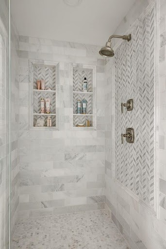 Compact small bathroom Shower Niche or Built-In Shelves with intricate herringbone patterned tile work and built-in shelves in a small bathroom. 