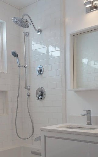Sleek small bathroom shower space with modern fittings, a Dual Showerheads set against understated tiling for a minimalist, functional design.
