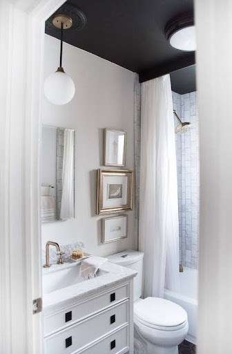Charming and efficient small bathroom layout with a  Tubular Skylight classic white scheme, a framed shower curtain, and smart mirror placement for a spacious ambiance.