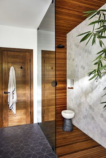 Modern cozy bathroom shower with dark Teak Wood Accents, and a wall niche, creating a natural and chic atmosphere.