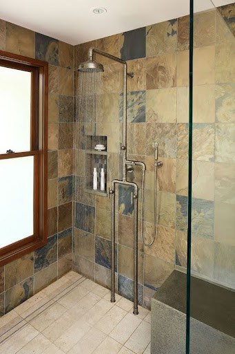 Rustic little bathroom shower with  Expose Plumbing Pipes, slate and sandstone tiles, featuring modern fixtures and a clear glass door for an earthy yet contemporary look.