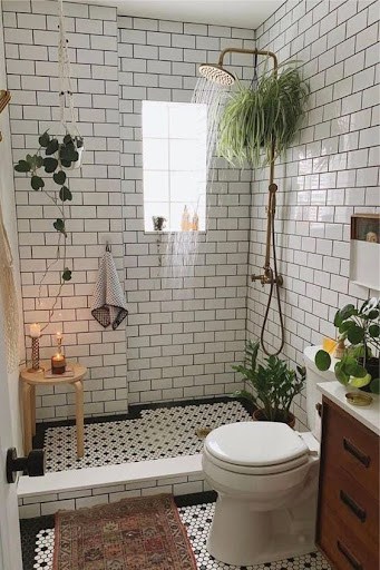 Quaint and inviting bathroom niche with a Shower Plant, ceiling-mounted rainfall showerhead, crisp subway tilework, and botanical adornments, creating a tranquil, spa-like retreat.