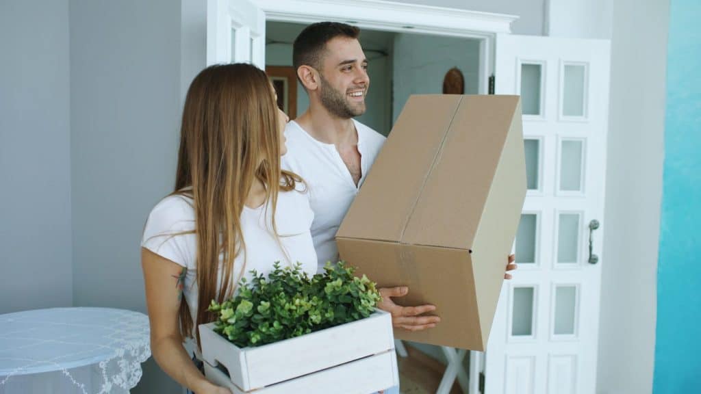 UNDERSTANDING HOPA: RULES FOR 55+ HOUSING COMMUNITIES 5 Couple carrying moving boxes into a new home